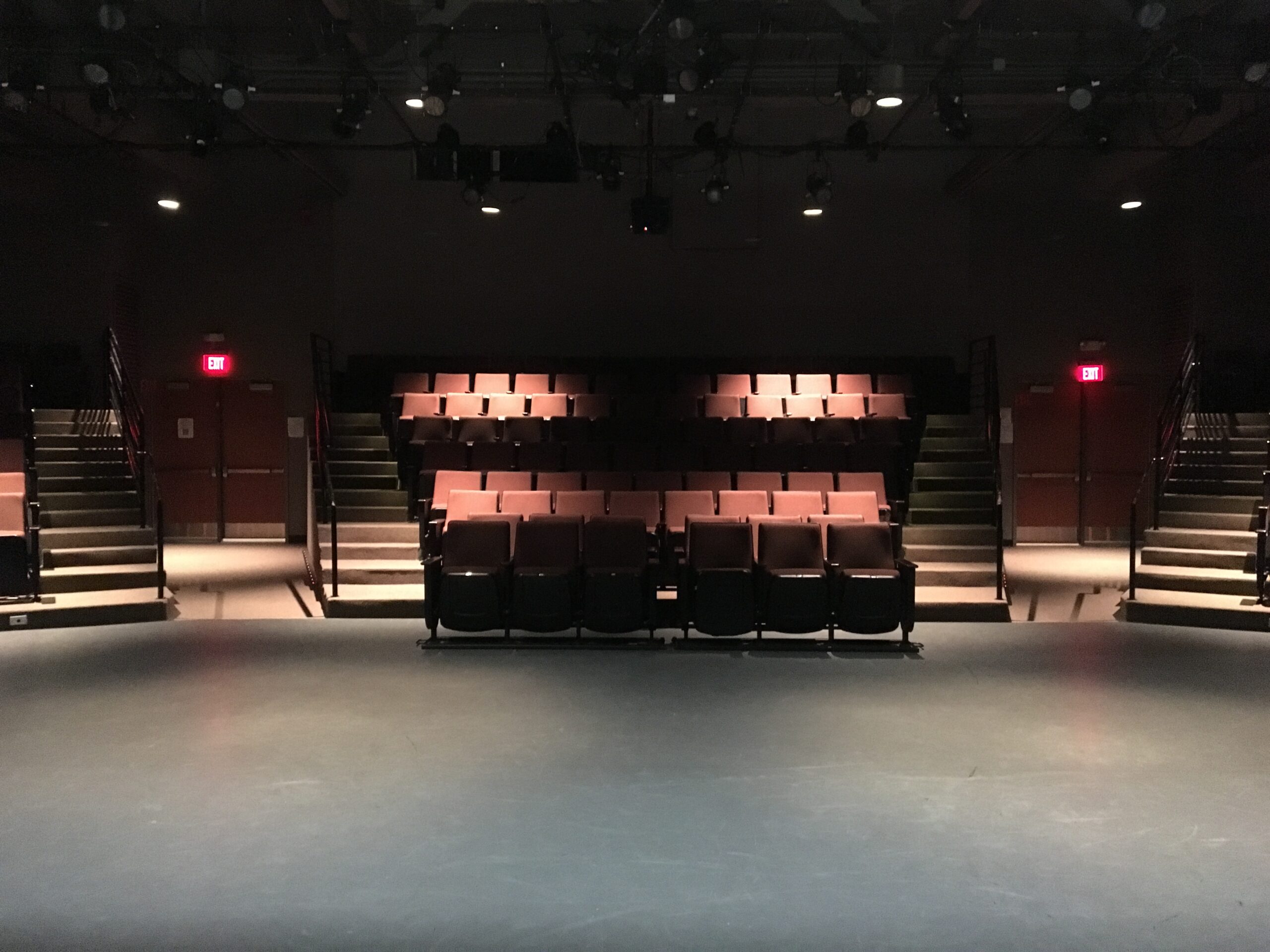 Image taken from the stage of an empty theatre looking out at the seating